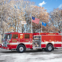 Engine 1 parked under flown flags in icy winter parking area - Warrenton Volunteer Fire Company