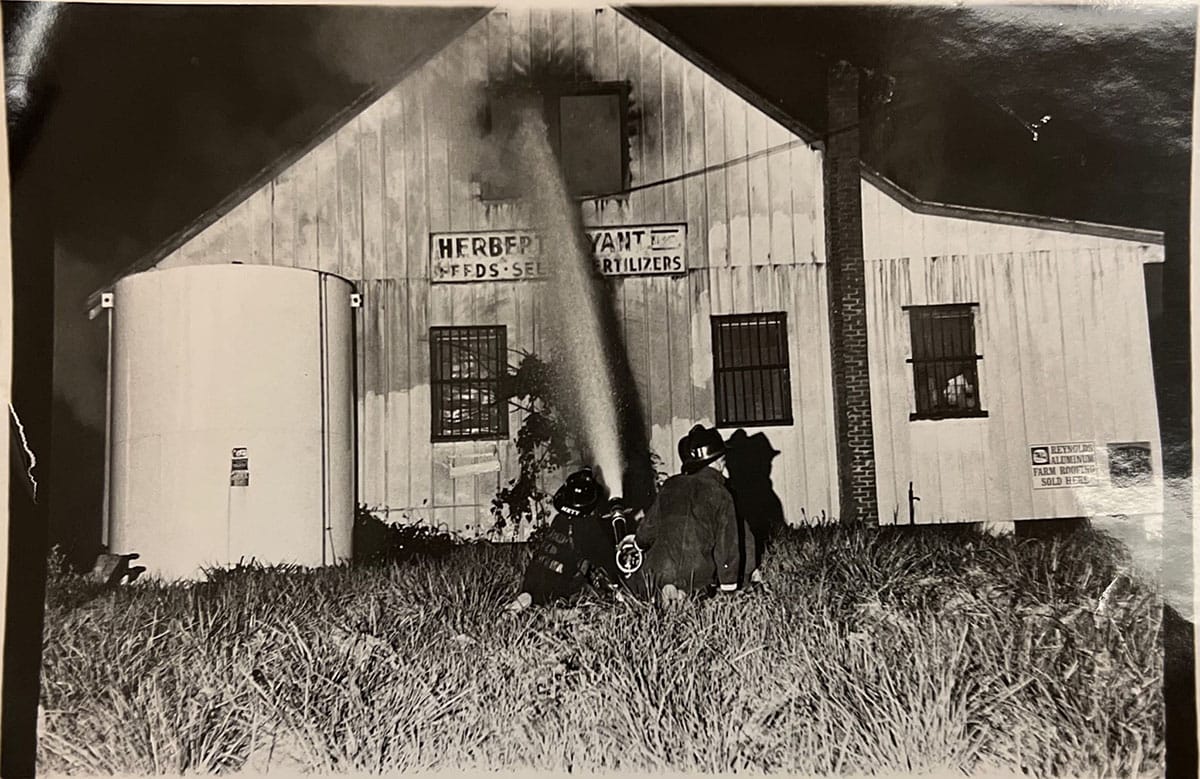 Old black and white photo of the Warrenton Volunteer Fire Company fighting a fire at the feed store on Falmouth Street